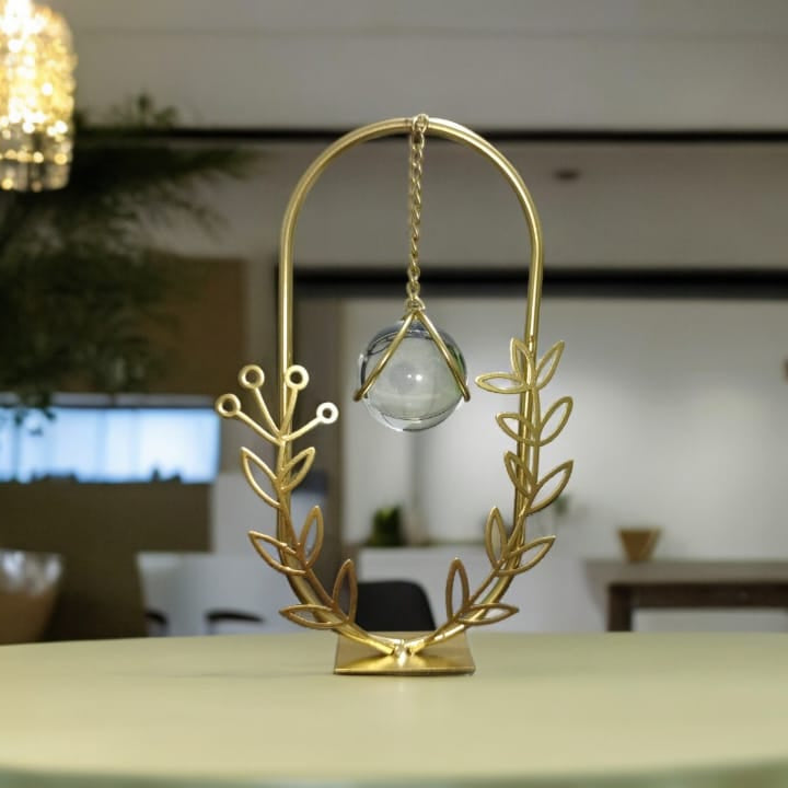 Gold decorative hanging item on a table with a blurred indoor setting