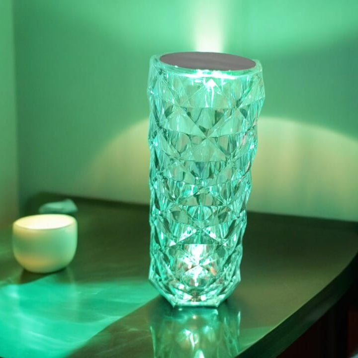 Crystal vase on a reflective surface with a soft green light